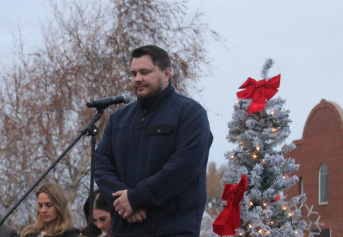 Pastor Josh Lagesse of Valley View Baptist Church prays at the City of Snowflake-Taylor Christmas Light the World Giving Machine event.